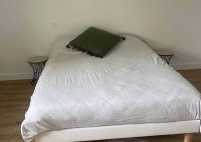 Lit double avec linge de lit blanc dans une chambre lumineuse