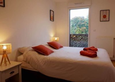 Chambre avec coussins rouges, grande fenêtre et décoration moderne