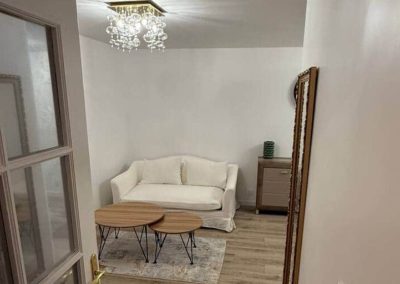 Salon secondaire avec canapé blanc et déco épurée