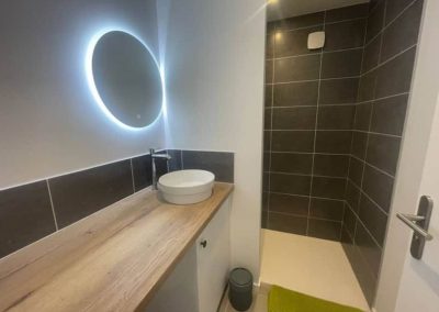 Salle de bain avec vasque ronde et grande douche à l’italienne