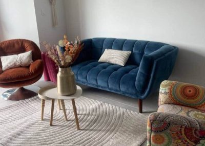 Canapé bleu et fauteuils colorés dans le salon